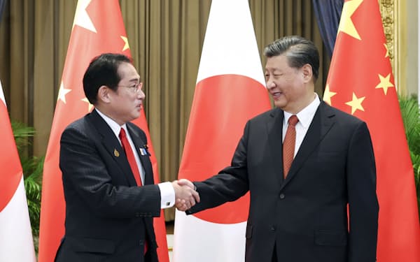 11月、バンコクで岸田首相（左）と握手する中国の習近平国家主席（新華社=共同）