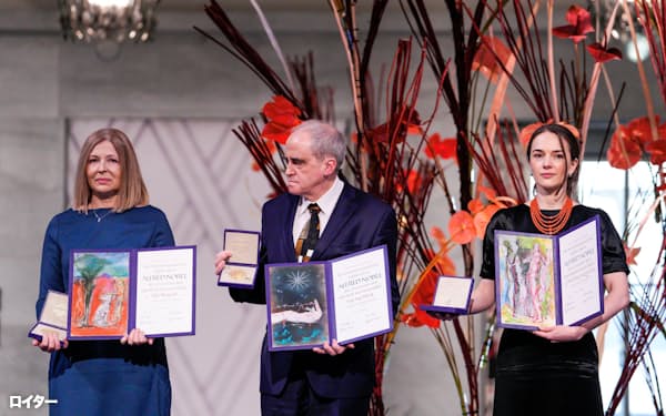 ノーベル平和賞を受賞したCCLのマトイチュク代表(右)、メモリアルのラチンスキー代表(中)、ビャリャツキ氏の妻ピンチュクさん(10日、オスロ)=ロイター