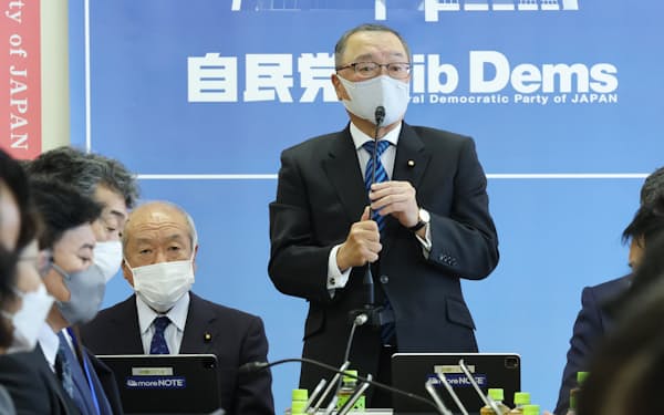 自民党税制調査会の総会であいさつする宮沢会長。左は鈴木財務相（18日、党本部）