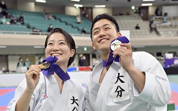 全日本選手権で優勝し、笑顔を見せる女子形の大野ひかる（左）と男子形の西山走（11日、日本武道館）＝共同