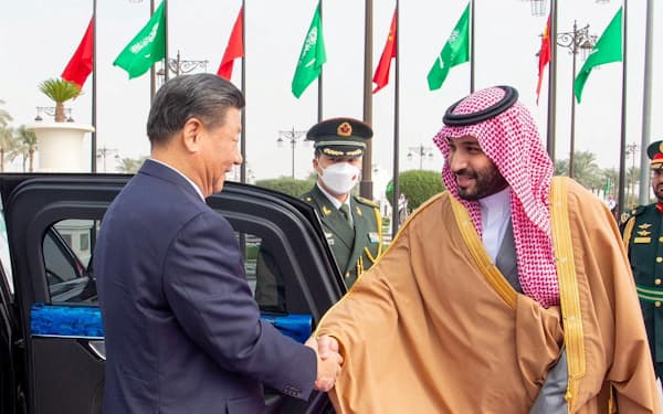 中国の習近平国家主席㊧と握手するサウジアラビアのムハンマド皇太子。人権や民主主義などの価値観で日米欧との溝が深まりかねない（８日、リヤド、サウジ国営通信提供）＝ロイター