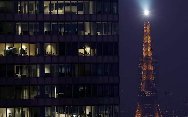 明かりのともされたエッフェル塔とパリのオフィスビル＝ロイター