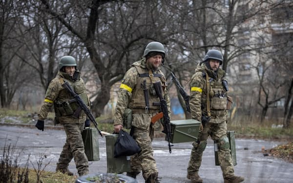ロシアのウクライナ攻撃が続く中、武器を運ぶウクライナの軍人たち（12月9日、ウクライナ・ドネツク州にて）＝ロイター