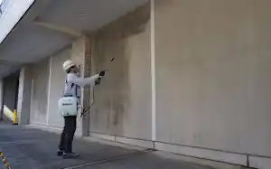 二酸化炭素(CO2)を多く吸収・固定できる含浸剤「DAC(ダック)コート」を東京都品川区第3庁舎の耐震壁の一部に噴霧塗装した。白線の左側に塗布し、塗布していない右側と比較しながら3年間経過を見る。2026年3月5日撮影(写真:日経クロステック) 二酸化炭素(CO2)を多く吸収・固定できる含浸剤「DAC(ダック)コート」を東京都品川区第3庁舎の耐震壁の一部に噴霧塗装した。白線の左側に塗布し、塗布していない右側と比較しながら3年間経過を見る。2026年3月5日撮影(写真:日経クロステック)