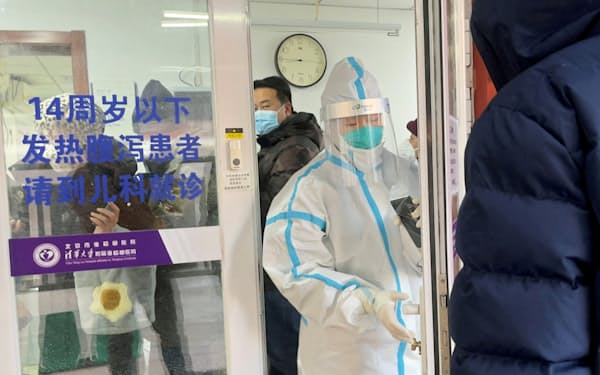 新型コロナの患者が増加するなか、対応にあたる病院の発熱外来のスタッフ（15日、北京）=ロイター