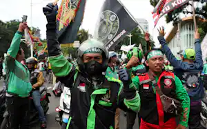 アプリの手数料の引き下げを求める配車アプリのドライバー(2025年5月、ジャカルタ)=ロイター アプリの手数料の引き下げを求める配車アプリのドライバー(2025年5月、ジャカルタ)=ロイター