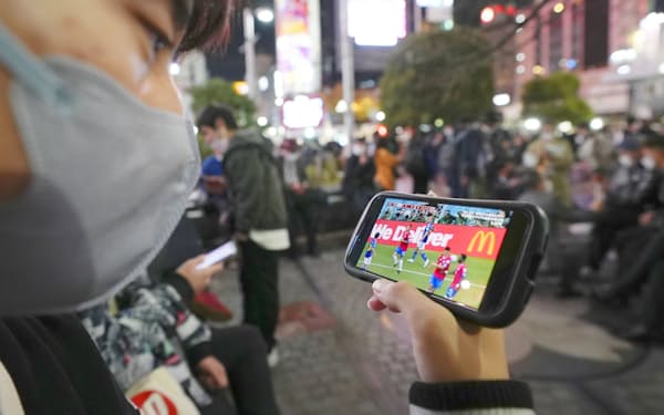 「ABEMA」でサッカーW杯カタール大会の日本戦を観戦する男性（11月27日、東京・渋谷）＝共同
