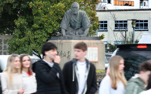 御所に向かい手をついて礼をする高山彦九郎の像。観光客や車が行き交う中をじっとたたずむ(京都市東山区)=松浦弘昌撮影