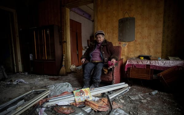 ウクライナ東部ドネツク州で、ロシア軍の攻撃で破壊された住居の中で座るウクライナの女性（17日）=ロイター