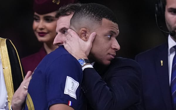 ワールドカップの決勝戦終了後、フランスのマクロン大統領の抱擁を受けるエムバペ選手＝ＡＰ