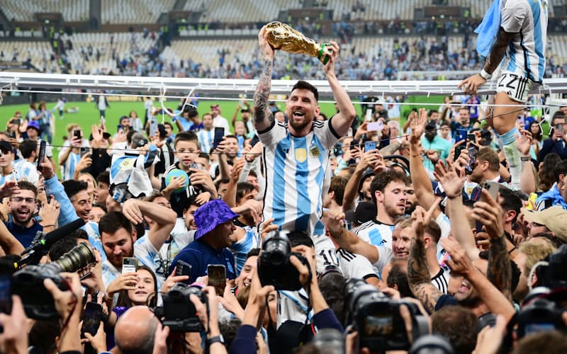 肩車され、優勝トロフィーを手に笑顔を見せるアルゼンチンのメッシ=目良友樹撮影