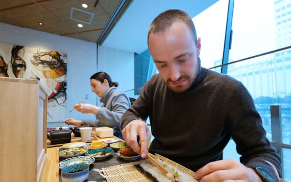 具材を乗せ自ら細巻き寿司を巻くイタリア人観光客（金沢市のコイル）

