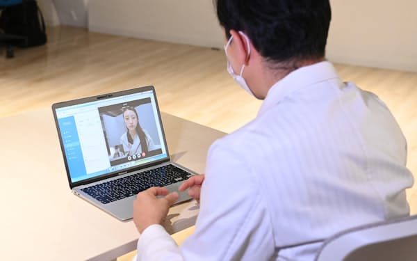 オンライン診療のデモンストレーションで、患者役の女性を診察する医師（12月、東京都渋谷区）