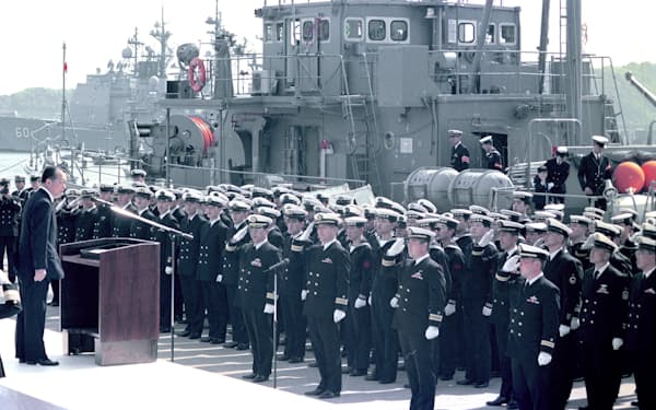 1991年4月、出発を前に依田防衛事務次官（左端）の訓示を聞く掃海艇の乗組員（神奈川県横須賀市の海上自衛隊横須賀基地）=共同