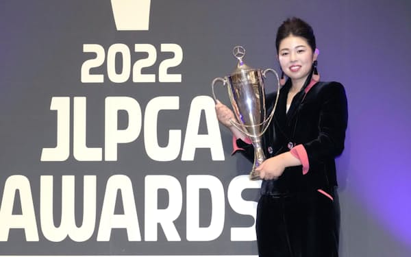 日本女子プロゴルフ協会の表彰式で、トロフィーを手に笑顔の山下美夢有＝共同
