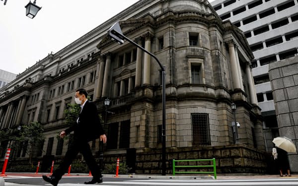 FILE PHOTO: A man wearing a protective mask walks past the headquarters of Bank of Japan in Tokyo, Japan, May 22, 2020. REUTERS/Kim Kyung-Hoon/File Photo