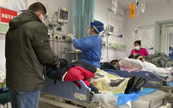 病院のベッドに横たわる患者ら（21日、河北省）＝ＡＰ