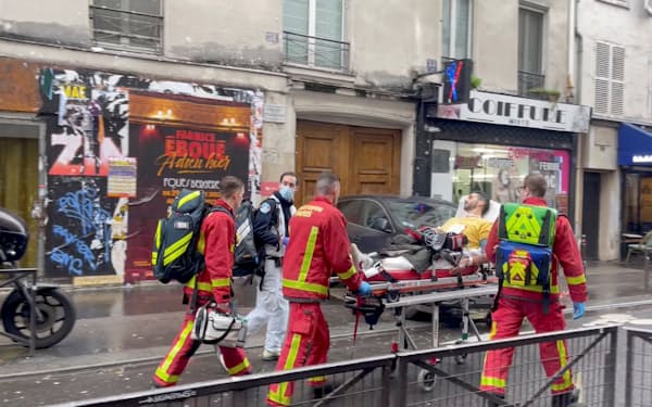 消防士によって運ばれるパリ中心部の発砲事件の被害者＝ロイター
