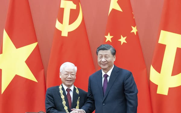 ベトナムのグエン・フー・チョン共産党書記長（左）と握手する中国の習近平国家主席（２０２２年１０月３１日、北京）＝新華社・共同