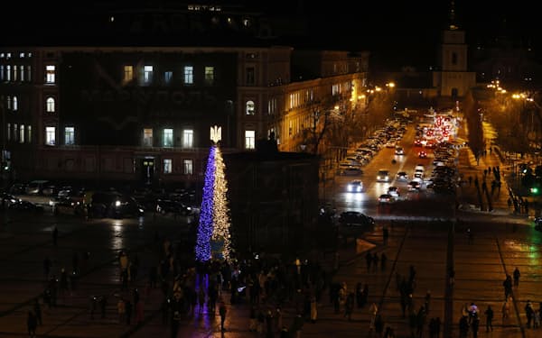 ウクライナの首都キーウ中心部の広場にクリスマスツリーが設置されている。ロシアによる攻撃で街の各所で停電が続く中、発電機を使って国旗と同色のイルミネーションがともされた。マイナス5度を下回る厳寒の中、人々はツリーを眺めて笑顔を浮かべ、幼い息子を連れて訪れた女性は「きれいに光るツリーを見て、子どもたちの気持ちが少しでも晴れればうれしい」と話した＝19日（共同）