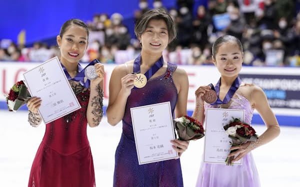 フィギュアスケートの全日本選手権女子で優勝し、メダルを手に笑顔の坂本花織（中央）。左は2位の三原舞依、右は3位の島田麻央（24日、東和薬品ラクタブドーム）＝共同