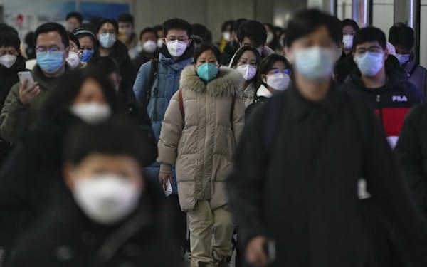 マスク姿の通勤客（20日、北京）＝AP
