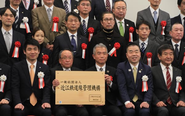近江鉄道の資産管理団体を設立した三日月大造知事（前列右から２番目）ら＝27日、東近江市役所