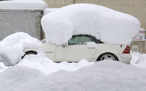長岡駅周辺で、降り続く雪に埋まった車＝19日午後、新潟県長岡市