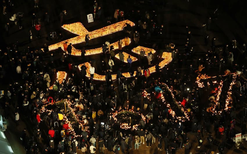 2022年1月17日、阪神大震災から27年を迎え、追悼会場に灯籠の明かりで浮かび上がった「忘　1・17」の文字（神戸市中央区の東遊園地）