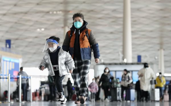 北京首都国際空港の出発ロビーでフェースシールドを着けて走る子ども（27日）＝共同