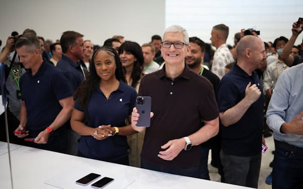 世界で使われるiPhoneは20億台前後に達する（アップル本社での新型iPhone発表イベントで談笑するティム・クック最高経営責任者、22年9月、米カリフォルニア州）＝ロイター