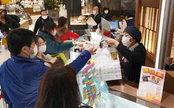 大丸心斎橋店の初売りでお菓子の福袋を買い求める人たち（2日、大阪市中央区）