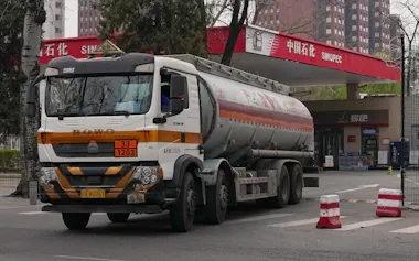 ガソリンスタンドへの配達を終えたタンクローリー(3月、北京)=AP