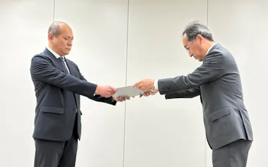 中部電の豊田原子力本部長㊨が規制庁の竹内検査監督総括課長に報告書を手渡した(31日午前、東京都港区)