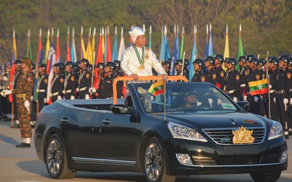 4日、ミャンマーの独立75周年記念式典で、車上から部隊を視察するミンアウンフライン氏