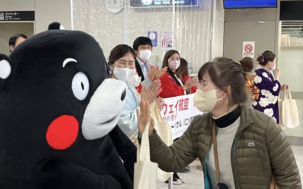 韓国からの観光客らをくまモンも出迎えた（５日、熊本空港）