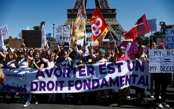 「中絶は基本的権利」と書かれたバナーを広げる、パリのデモ参加者たち（2022年7月）＝ロイター