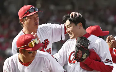 プロ6年目で初先発初完封勝利を挙げた広島・栗林(右)。新井監督(左上)の「遊び」の提案を生かし、快投を演じた=共同