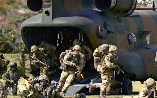 輸送ヘリコプターから降りる英陸軍の兵士と自衛隊員（18年10月、静岡県小山町の陸上自衛隊富士学校）