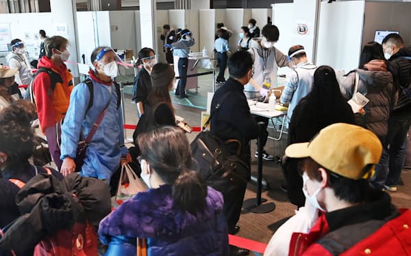 コロナの抗原検査を受けるために並ぶ中国発航空便の搭乗客(8日、成田空港)