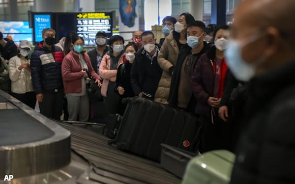 中国の北京首都国際空港で、荷物を待つ旅行者ら(9日)=AP