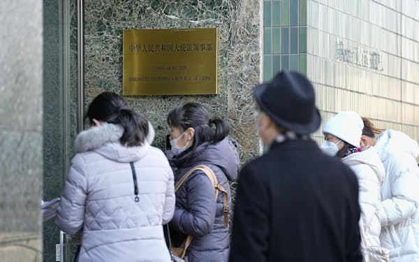中国大使館領事部を訪れた人たち。中国政府は日本でのビザの発給手続きを停止している＝11日午前、東京都品川区、共同