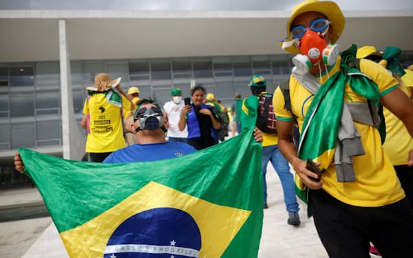 ブラジル国旗を掲げて議会に侵入したボルソナロ前大統領の支持者ら（8日）=ロイター