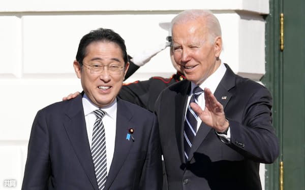 首脳会談を前にバイデン米大統領(右)の出迎えを受ける岸田首相(13日、ワシントンのホワイトハウス)=共同