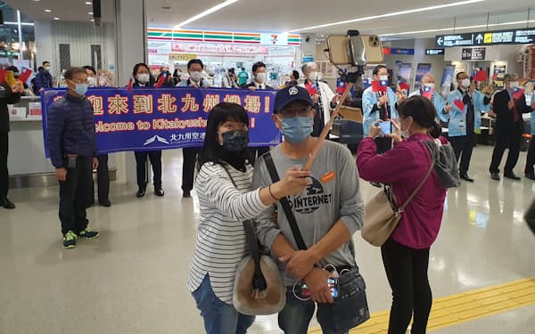 出迎えの関係者をバックに記念撮影する、台湾からの旅行者（15日、北九州空港）