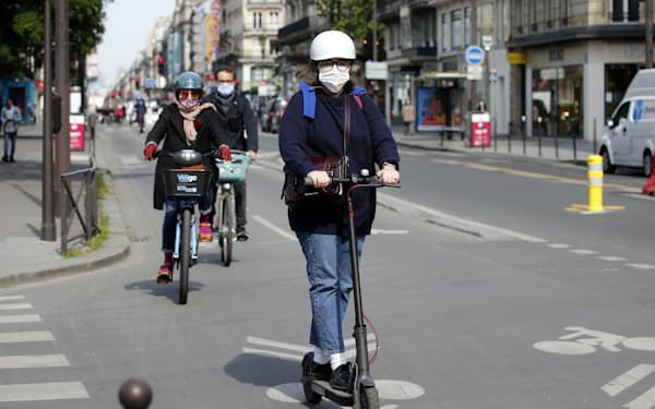 電動キックボードで走行する女性（2020年5月、フランス・パリ）＝ゲッティ・共同