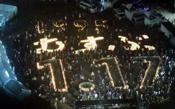 阪神大震災から28年を迎え、灯籠の明かりで浮かび上がった「1995 むすぶ 1.17」の文字(17日午前、神戸市中央区の東遊園地)