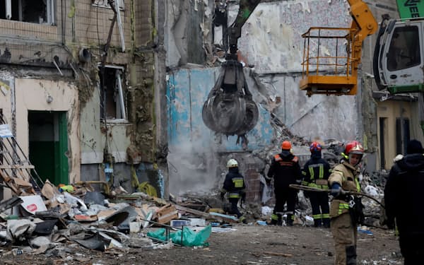 ロシア軍の攻撃が続くなか、破壊された集合住宅で捜索活動をする救急隊員（16日、ウクライナ東部ドニプロ）=ロイター