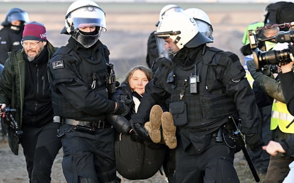 １７日、炭鉱拡張計画のあるドイツの集落で警察に強制退去させられる環境活動家のグレタさん㊥＝ＡＰ