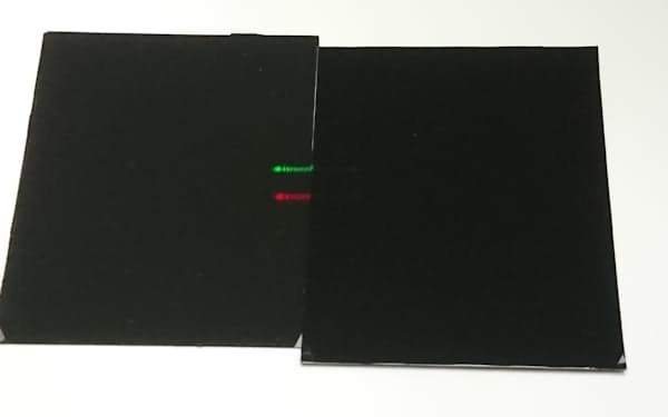 今回開発した「暗黒シート」（右）はレーザー光も吸収する。左は従来のシートで赤と緑の光が見える（18日、つくば市の産総研）
